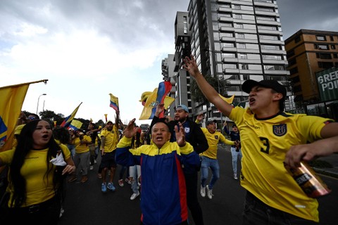 Penggemar Timnas Ekuador berselebrasi di jalan, setelah tim kesayangannya mengalahkan Timnas Qatar dalam pertandingan pembukaan Piala Dunia 2022 di Quito, Ekuador, Minggu (20/11/2022). Foto: Rodrigo Buendia/AFP