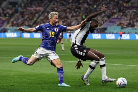 Pemain Timnas Jepang Takuma Asano berebut bola dengan pemain Timmas Jerman Antonio Rudiger pada pertandingan Grup E Piala Dunia 2022 Qatar di Stadion Internasional Khalifa, Doha, Qatar. Foto: Matthew Childs/REUTERS