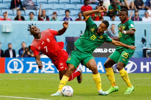 Pemain Timnas Swiss Breel Embolo berusaha melewati pemain Timnas Kamerun Nouhou Tolo dan Jean-Charles Castelletto pada pertandingan Grup G Piala Dunia 2022 Qatar di Stadion Al Janoub, Al Wakrah, Qatar Foto: Issei Kato/REUTERS