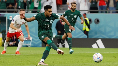 Pemain Arab Saudi Salem Al-Dawsari melakukan tendangan penalti ke gawang Polandia pada Piala Dunia 2022, di Education City Stadium, Al Rayyan, Qatar, sabtu (26/11/2022). Foto: Issei Kato/REUTERS