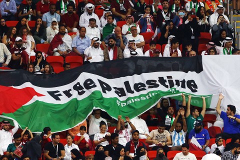 Suporter membentangkan bendera Palestina saat pertandingan Timnas Belanda melawan Qatar pada pertandingan Grup A Piala Dunia 2022 Qatar di Stadion Al Bayt, Al Khor, Qatar. Foto: Bernadett Szabo/REUTERS
