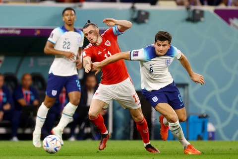 Pemain Timnas Inggris Harry Maguire berebut bola dengan pemain Timnas Wales Gareth Bale pada pertandingan Grup B Piala Dunia 2022 Qatar di Stadion Ahmad Bin Ali, Al Rayyan, Qatar. Foto: Paul Childs/REUTERS