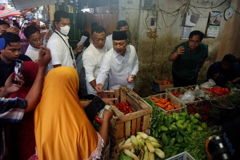 Menteri Perdagangan Zulkifli Hasan (tengah) membeli sembako untuk dibagikan kepada warga di salah satu pedagang sembako Pasar Stasiun di Ponorogo, Jawa Timur, Minggu (25/12/2022). Foto: Destyan Sujarwoko/ANTARA FOTO