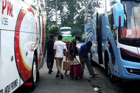 Penumpang mengambil barang setelah turun dari Bus di Terminal Kampung Rambutan pada Minggu (1/1/2023). Foto: Iqbal Firdaus/kumparan