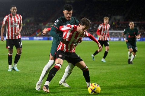 Pemain Liverpool Alex Oxlade-Chamberlai berebut bola dengan pemain Brentford  pada apertandingan lanjutan LIga Inggris di Stadion Komunitas Brentford, London, Inggris. Foto: Toby Melville/REUTERS