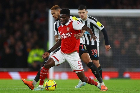 Pemain Arsenal Thomas Partey berebut bola dengan pemain Newcastle United Joelinton pada pertandingan lanjutan Liga Inggris di Stadion Emirates, London, Inggris. Foto: Paul Childs/REUTERS