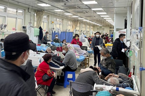 Pasien berbaring di tempat tidur dan tandu di lorong di unit gawat darurat rumah sakit, di tengah wabah COVID-19 di Shanghai, China, Rabu (4/1/2022). Foto: Staff/REUTERS