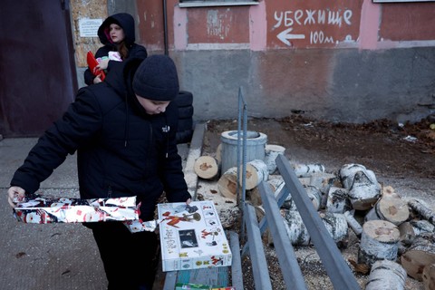Relawan membagikan hadiah natal untuk anak-anak di wilayah di Bakhmut, Ukraina. Foto: Clodagh Kilcoyne/REUTERS
