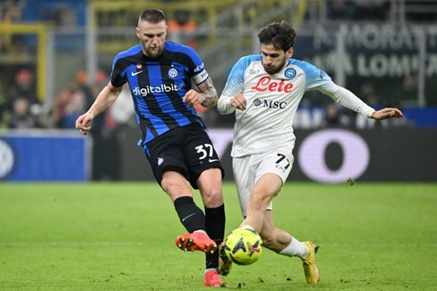 Pemain Inter Milan Milan Skriniar berebut bola dengan pemain Napoli Khvicha Kvaratskhelia pada pertandingan lanjutan Liga Italia di Stadion San Siro, Milan, Italia.  Foto: Alberto Lingria/REUTERS