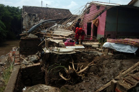 Petugas dan warga membersihkan puing-puing rumah yang hancur diterjang banjir bandang di Desa Kemiriamba, Jatibarang, Brebes, Jawa Tengah, Kamis (5/1/2023). Foto: Oky Lukmansyah/Antara Foto