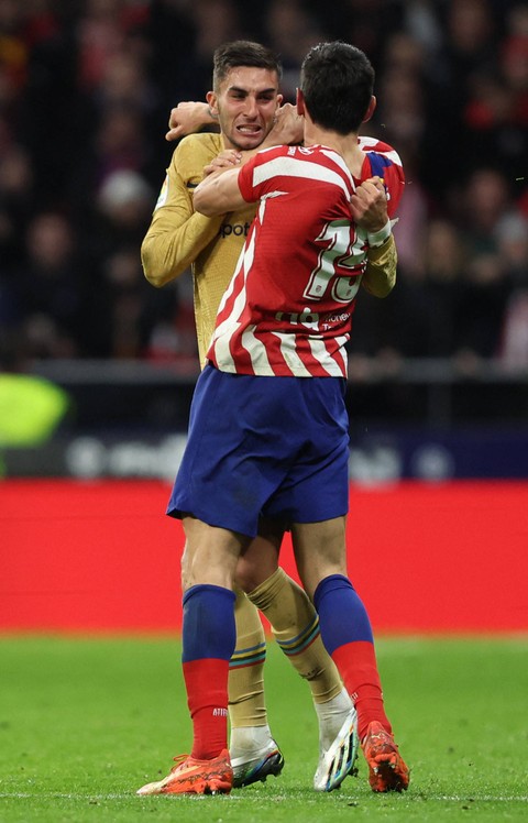Pemain Barcelona Ferran Torres (kiri) berkelahi dengan pemain Atletico Madrid Stefan Savic pada pertandingan di Metropolitano, Madrid, Spanyol. Foto: Thomas Coex/AFP