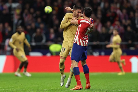 Pemain Barcelona Ferran Torres (kiri) berkelahi dengan pemain Atletico Madrid Stefan Savic pada pertandingan di Metropolitano, Madrid, Spanyol. Foto: Thomas Coex/AFP