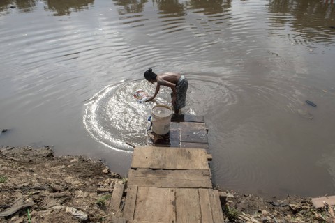Warga mengambil air dari aliran Sungai Banjir Kanal Barat untuk kebutuhan sehari-hari di Jakarta, Senin (9/1/2023). Foto: ANTARA FOTO/Muhammad Adimaja