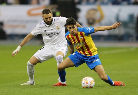 Andre Almeida dari Valencia beraksi dengan Karim Benzema dari Real Madrid saat pertandingan di Stadion King Fahd, Riyadh, Arab Saudi. Foto: Ahmed Yosri/Reuters