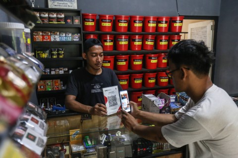 Pembeli bertransaksi menggunakan QRIS saat membeli tembakau di Lakonte Bacco, Depok, Jawa Barat, Rabu (4/1/2023). Foto: Asprilla Dwi Adha/Antara Foto
