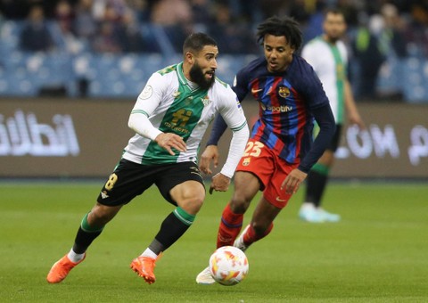 Nabil Fekir dari Real Betis duel dengan Jules Kounde dari FC Barcelona saat pertandingan di Stadion King Fahd, Riyadh, Arab Saudi. Foto: Ahmed Yosri/Reuters