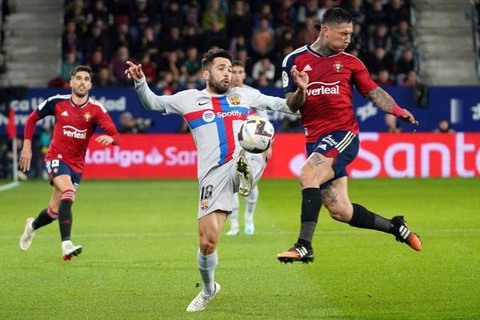 Pemain FC Bacelona Jordi Alba berebut bola dengan pemain Osasuna pada pertandingan lanjutan Liga Spanyol di stadion El Sadar, Pamplona, Spanyol.Foto: Cesar Manso/AFP