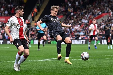 Pemain Arsenal Martin Odegaard berebut bola dengan pemain  Southampton  pada pertandingan lanjutan Liga Inggris di Stadion St Mary, Southampton, Inggris. Foto: Dylan Martinez/REUTERS