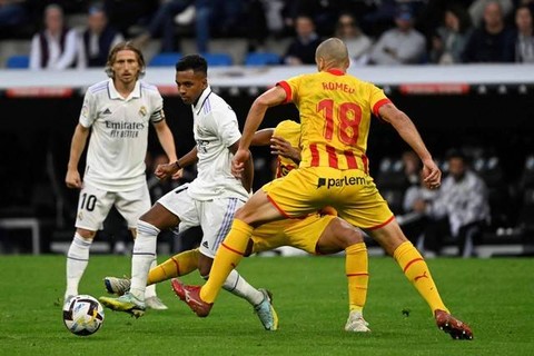 Pemain depan Real Madrid Rodrygo duel dengan pemain Girona Oriol Romeu di pertandingan liga Spanyol di stadion Santiago Bernabeu, Madrid. Foto: Pierre-Philippe Marcou/AFP