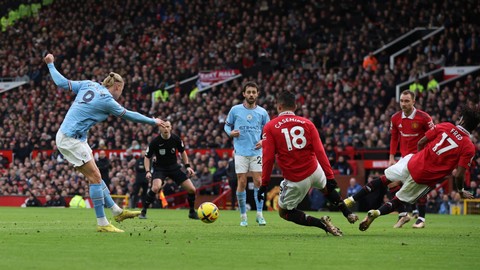 Pemain Manchester United Casemiro berusaha menghalu bola tendangan pemain Manchester City Erling Braut Haaland pada pertandingan lanjutan Liga Inggris di Old Trafford, Manchester, Inggris, Sabtu (14/1/2023). Foto: Phil Noble/REUTERS