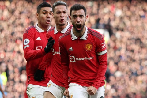 Pemain Manchester United Bruno Fernandes merayakan gol pertama mereka dengan Casemiro dan Antony saat melawan Manchester City di Stadion Old Trafford, Manchester, Inggris, Sabtu (14/1/2023). Foto: Phil Noble/REUTERS