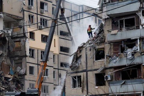 Tim penyelamat melakukan pencarian korban serangan rudal Rusia yang menghantam apartemen di Kota Dnipro, Ukraina, Minggu (15/1/2023).  Foto: Clodagh Kilcoyne/REUTERS