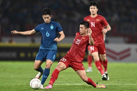 Sarach Yooyen (Kiri) dari Thailand dan Phan Van Duc dari Vietnam (depan kanan) memperebutkan bola pada leg kedua pertandingan sepak bola final Piala AFF antara Vietnam dan Thailand di Stadion Thammasat di Bangkok pada 16 Januari 2023. Foto: Lillian SUWANRUMPHA/AFP