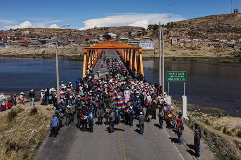 Anggota komunitas Aymara memblokade Jembatan Internasional Ilave saat menuntut Presiden Peru Dina Boluarte untuk mengundurkan diri di Ilave, Puno, Peru pada Senin (16/1/2023). Foto: Juan Carlos Cisneros/AFP