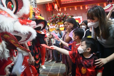 Anak-anak memasukkan angpao ke dalam mulut barongsai yang beraksi di Vihara Dhanagun, Kota Bogor, Jawa Barat, Sabtu (21/1/2023). Foto: Arif Firmansyah/ANTARA FOTO