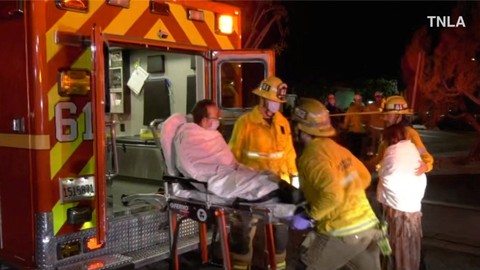 Petugas tanggap darurat membantu seseorang ke ambulans setelah penembakan di Monterey Park, California, AS, Minggu (22/1/2023). Foto: TNLA/Handout via REUTERS