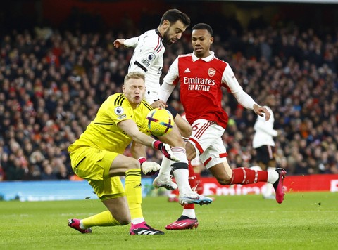 Aaron Ramsdale dari Arsenal duel dengan Bruno Fernandes dari Manchester United saat pertandingan di Stadion Emirates, London, Inggris. Foto: Peter Cziborra/Reuters