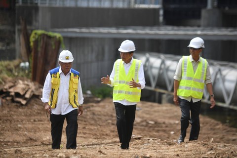 Presiden Joko Widodo (tengah) didampingi Menteri PUPR Basuki Hadimuljono (kiri) dan Pj Gubernur DKI Jakarta Heru Budi Hartono meninjau proyek pembangunan sodetan Kali Ciliwung di Jakarta, Selasa (24/1/2023). Foto: Hafidz Mubarak A/ANTARA FOTO