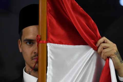 Pesepak bola Shayne Pattynama berpose dengan bendera Merah Putih usai pembacaan sumpah menjadi Warga Negara Indonesia (WNI) di Jakarta, Selasa (24/1/2023). Foto: Aditya Pradana Putra/ANTARA FOTO