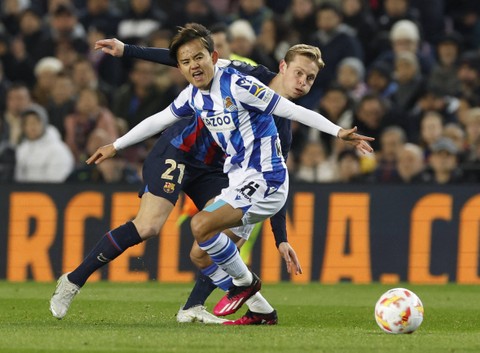 Takefusa Kubo dari Real Sociedad duel dengan Frenkie de Jong dari FC Barcelona saat pertandingan di Camp Nou, Barcelona, Spanyol. Foto: Albert Gea/Reuters