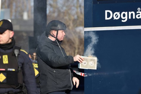 Politisi sayap kanan Rasmus Paludan membakar salinan Al-quran saat protes di depan sebuah masjid di Noerrebro, di Kopenhagen, Denmark, Jumat (27/1/2023). Foto: Ritzau Scanpix/Olafur Steinar Gestsson via REUTERS