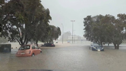 Mobil terlihat di jalanan yang tergenang banjir saat hujan lebat di Auckland, Selandia Baru, Jumat (27/1/2023). Foto: @MonteChristoNZ/via REUTERS