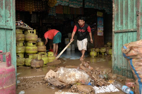 Sejumlah warga membersihkan toko miliknya usai banjir di Kelurahan Bailang, Manado, Sulawesi Utara, Sabtu (28/1/2023).  Foto: Adwit B Pramono/ANTARA FOTO