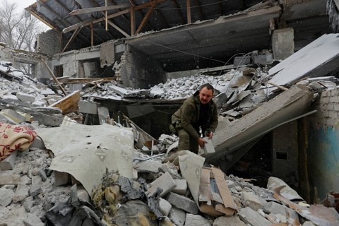 Anggota dinas Rusia memindahkan puing-puing bangunan rumah sakit yang hancur, oleh serangan rudal Ukraina, di pemukiman Novoaidar, wilayah Luhansk, Ukraina yang dikuasai Rusia, Minggu (29/1/2023). Foto: Alexander Ermochenko/REUTERS