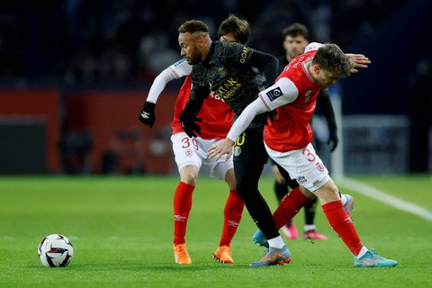 Pemain Paris St Germain Neymar beraksi dengan pemain Stade de Reims 'Junya Ito dan Thomas Foket di Parc des Princes, Paris, Prancis , Minggu (29/1/2023) Foto: Christian Hartmann/REUTERS