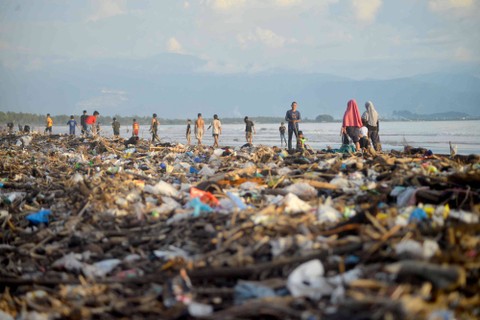 Pengunjung melewati sampah yang memenuhi tepi Pantai Pasir Jambak, Padang, Sumatera Barat, Minggu (29/1/2023). Foto: ANTARA FOTO/Iggoy el Fitra