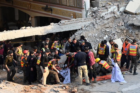 Petugas penyelamat mencari korban ledakan di sebuah masjid di Peshawar, Pakistan, Senin (30/1/2023). Foto: Maaz ALI / AFP