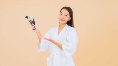 Ilustrasi perempuan menggunakan kuas makeup. Foto: Lifestyle Travel Photo/shutterstock