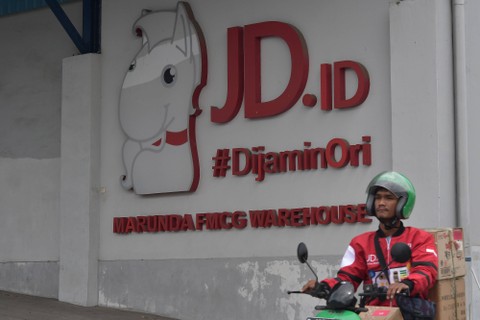 Seorang pekerja mengendarai sepeda motor melintas di depan gudang JD.ID, Kabupaten Bekasi, Jawa Barat, Selasa (31/1/2023). Foto: ANTARA FOTO/Fakhri Hermansyah