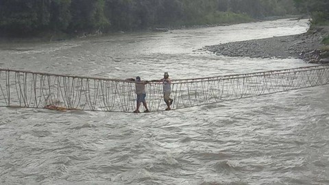 Warga melintas di jembatan gantung yang membentang di Sungai Digoel, Kabupaten Pegunungan Bintang Provinsi Papua Pegunungan. Foto: Abdel Syah/BumiPapua