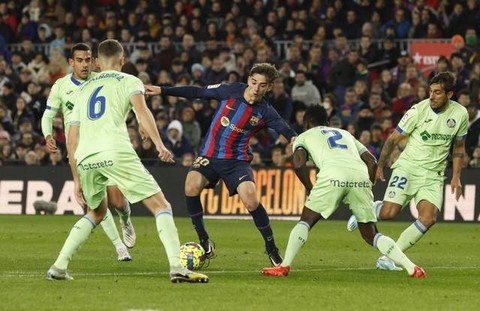 Gavi dari FC Barcelona beraksi dengan Domingos Duarte, Djene dan Damian Suarez dari Getafe di Camp Nou, Barcelona, Spanyol. Foto: Albert Gea/Reuters