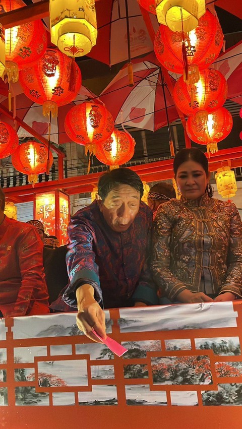 Peserta pawai lampion membagikan angpao kepada penonton yang menyaksikan festival tersebut. Foto: Leo Prima/Hi!Pontianak