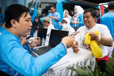 Petugas dari Dinas Kependudukan dan Catatan Sipil (Disdukcapil) Kota Palembang melakukan perekaman data KTP Elektronik di halaman kantor DPRD Provinsi Sumatera Selatan, Palembang, Sabtu (4/2/2023). Foto: Nova Wahyudi/Antara Foto