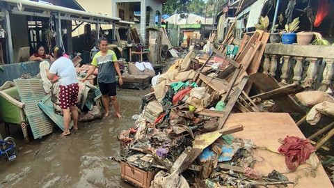 Warga membersihkan lumpur dan sampah sisa banjir yang terjadi pada Jumat 27 Januari 2023.