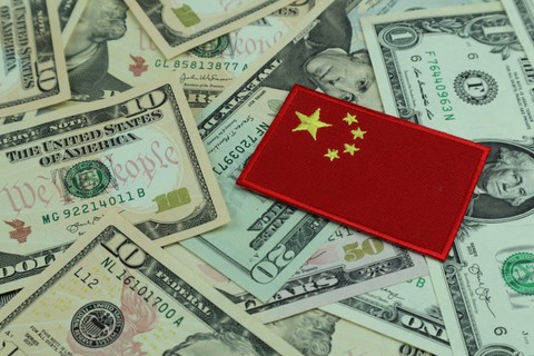 Ilustrasi uang dolar dan bendera China. Foto: Shutterstock