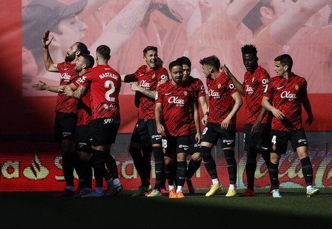 Vedat Muriqi dari Real Mallorca merayakan gol pertamanya bersama rekan setimnya di laga Real Mallorca vs Real Madrid dalam laga lanjutan Liga Spanyol 2022/23 di Stadion Mallorca, Palma, Mallorca, Spanyol. Foto: Juan Medina/Reuters